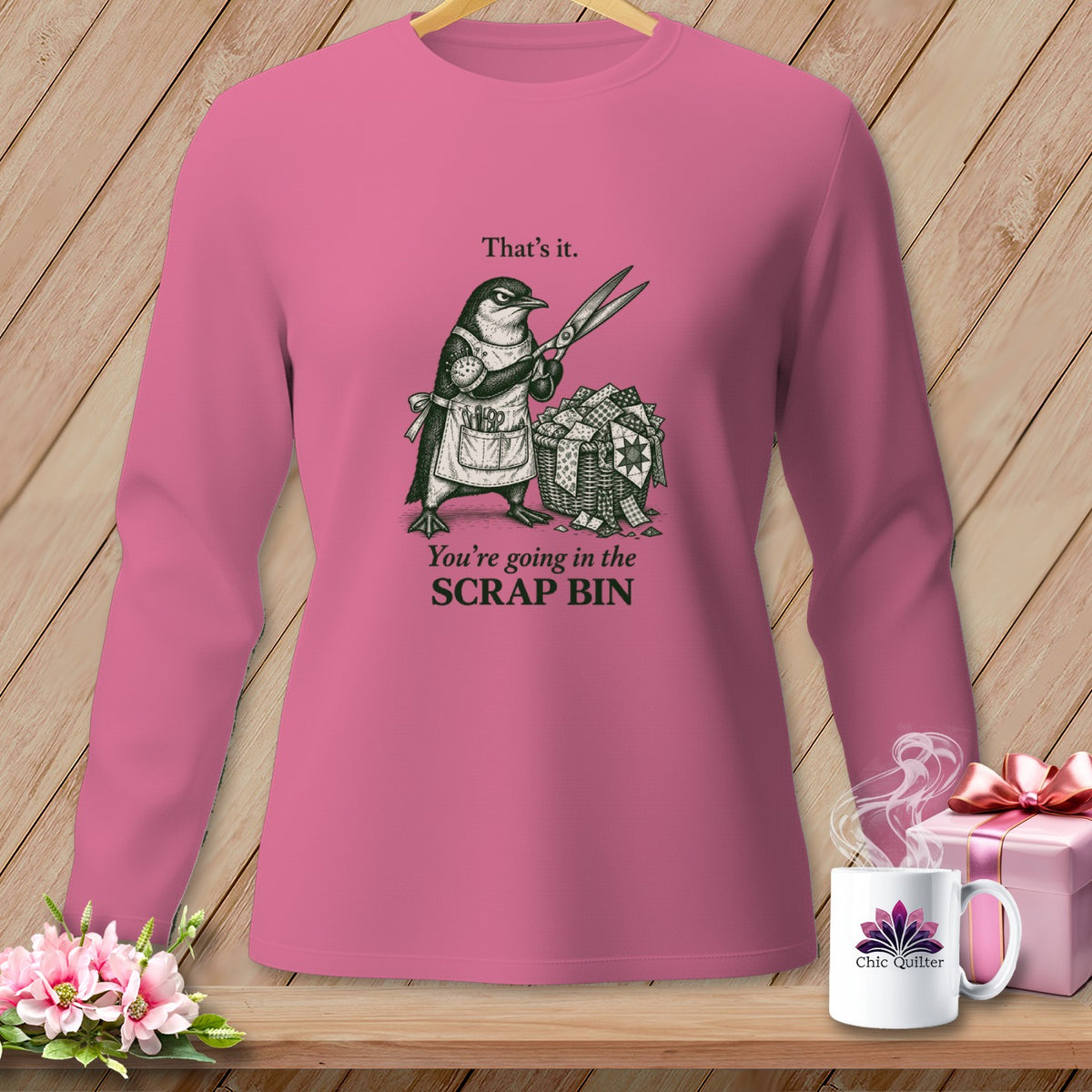 Pink long-sleeved shirt with a penguin graphic and text "That's it. You're going in the SCRAP BIN."