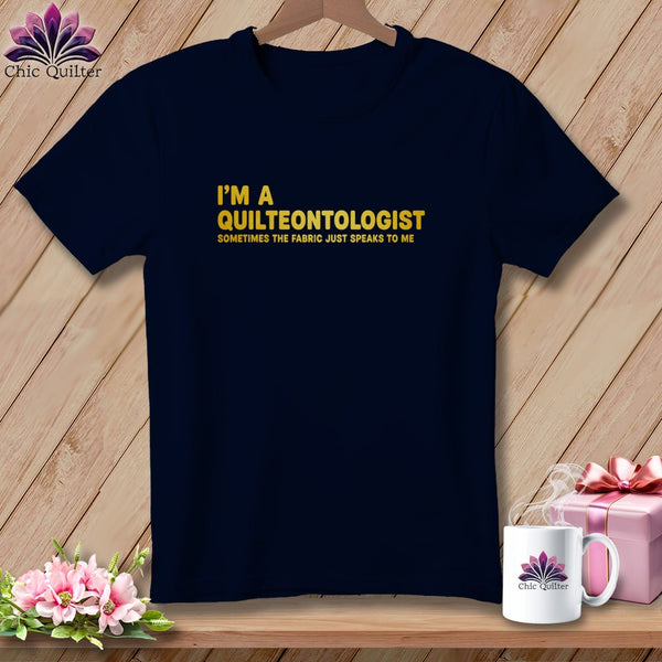 Dark navy t-shirt with "I'm a Quilteontologist Sometimes the fabric just speaks to me" text.