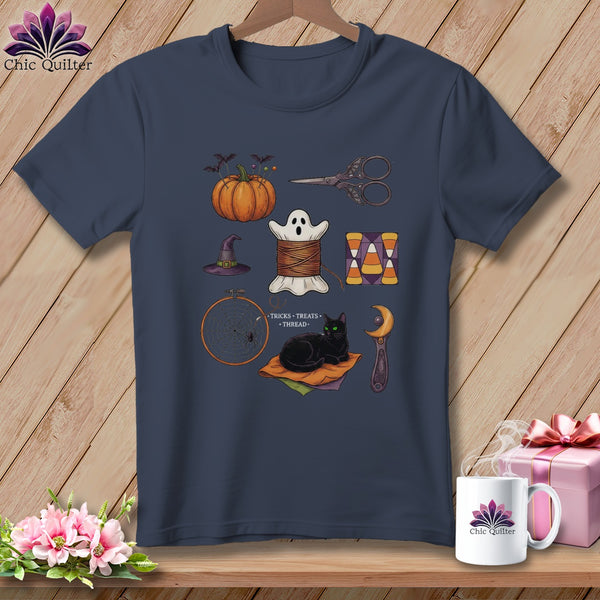 Dark navy t-shirt with Halloween sewing graphics: pumpkin, ghost, scissors, hat, thread, candy corn, spiderweb, black cat.