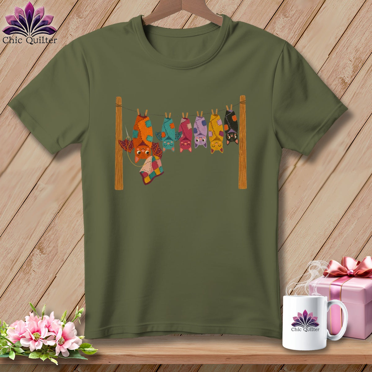 Green t-shirt with a colorful quilt-like bat design hanging on a clothesline.