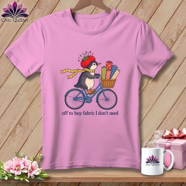 Penguin riding bicycle with fabric rolls, wearing tomato pincushion hat.
