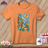 An orange crewneck t-shirt features a colorful, swirling quilting graphic on the front, displayed against a wooden background.