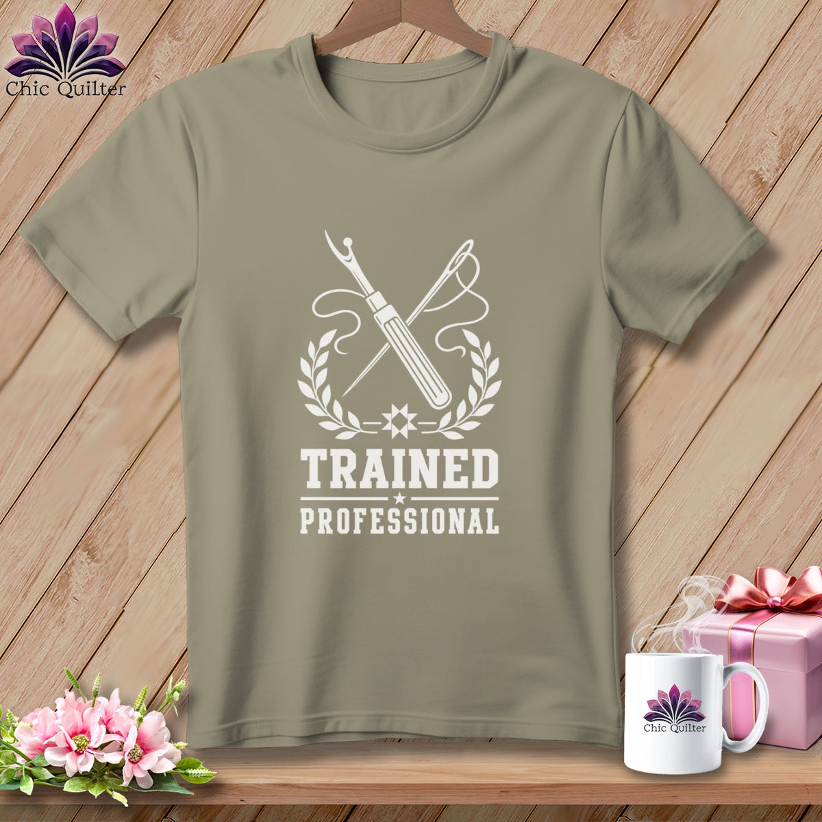 T-shirt with white graphic of sewing tools, wreath, and text "TRAINED PROFESSIONAL".