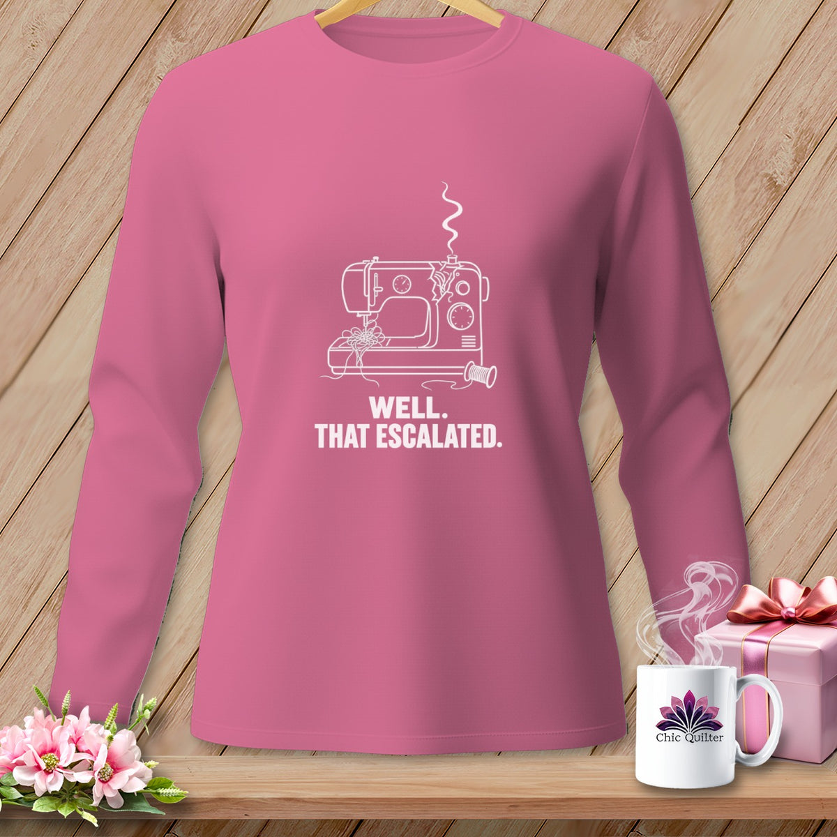 Pink long-sleeve shirt with white sewing machine graphic and text.