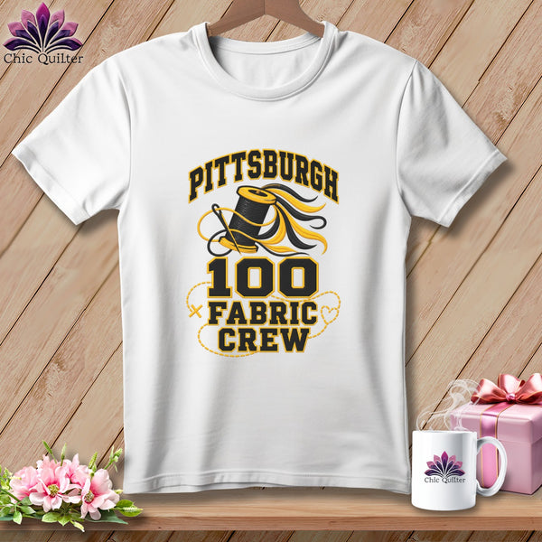A white crewneck t-shirt featuring a Pittsburgh 100 Fabric Crew graphic with a spool of thread.