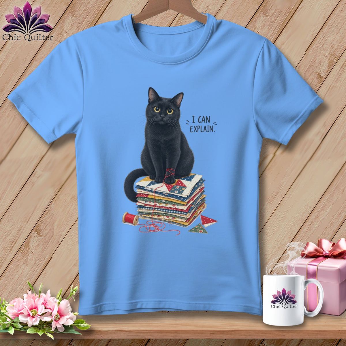 Light blue t-shirt with a black cat sitting on a stack of quilts, reading "I CAN EXPLAIN."