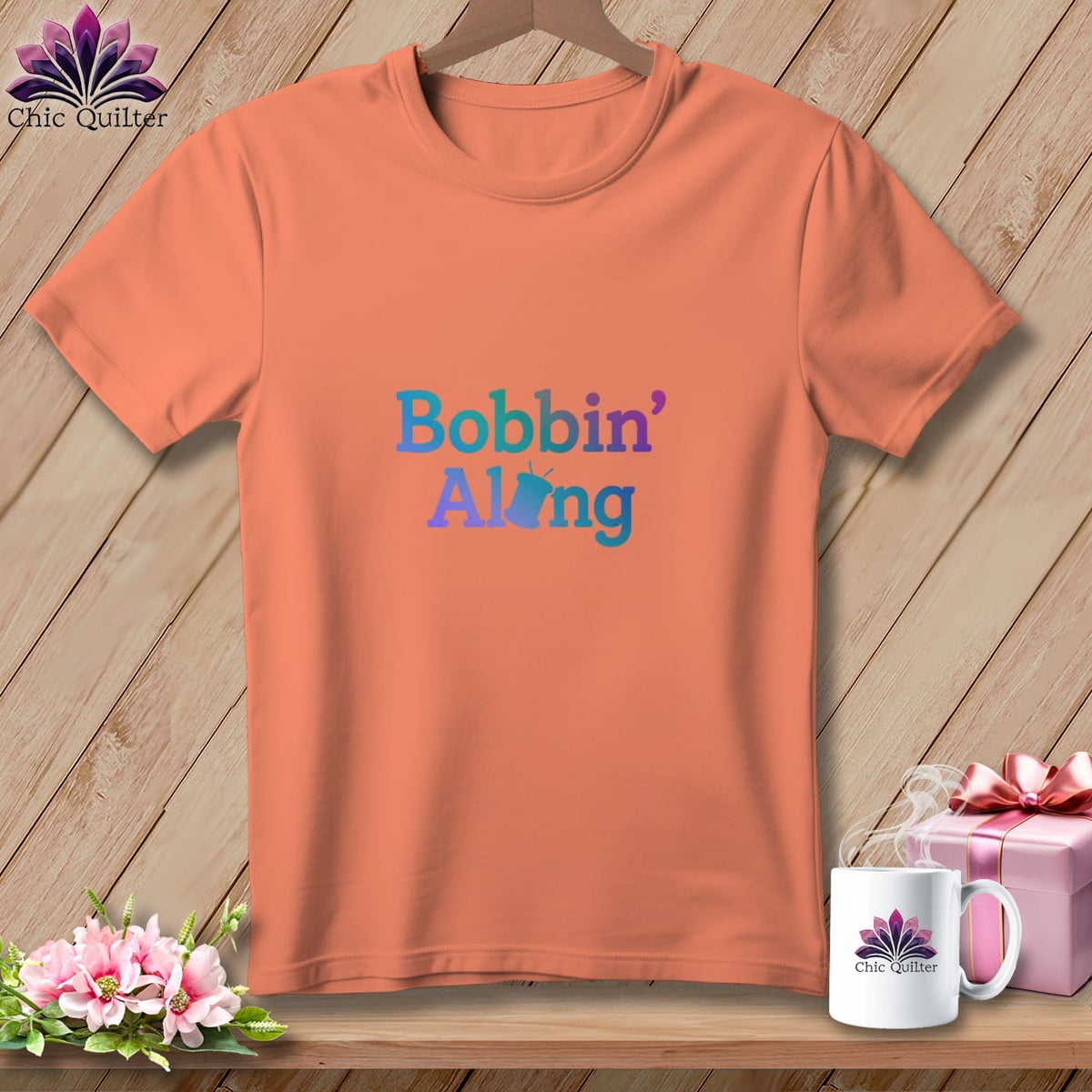 Peach t-shirt with gradient text reading "Bobbin' Along" and a small bobbin graphic.