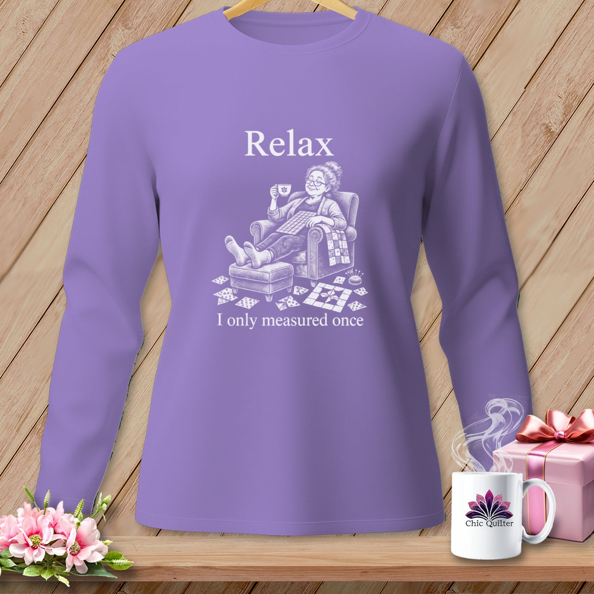 Purple long-sleeve shirt with a graphic of a woman relaxing with a cup of tea and quilting pieces.