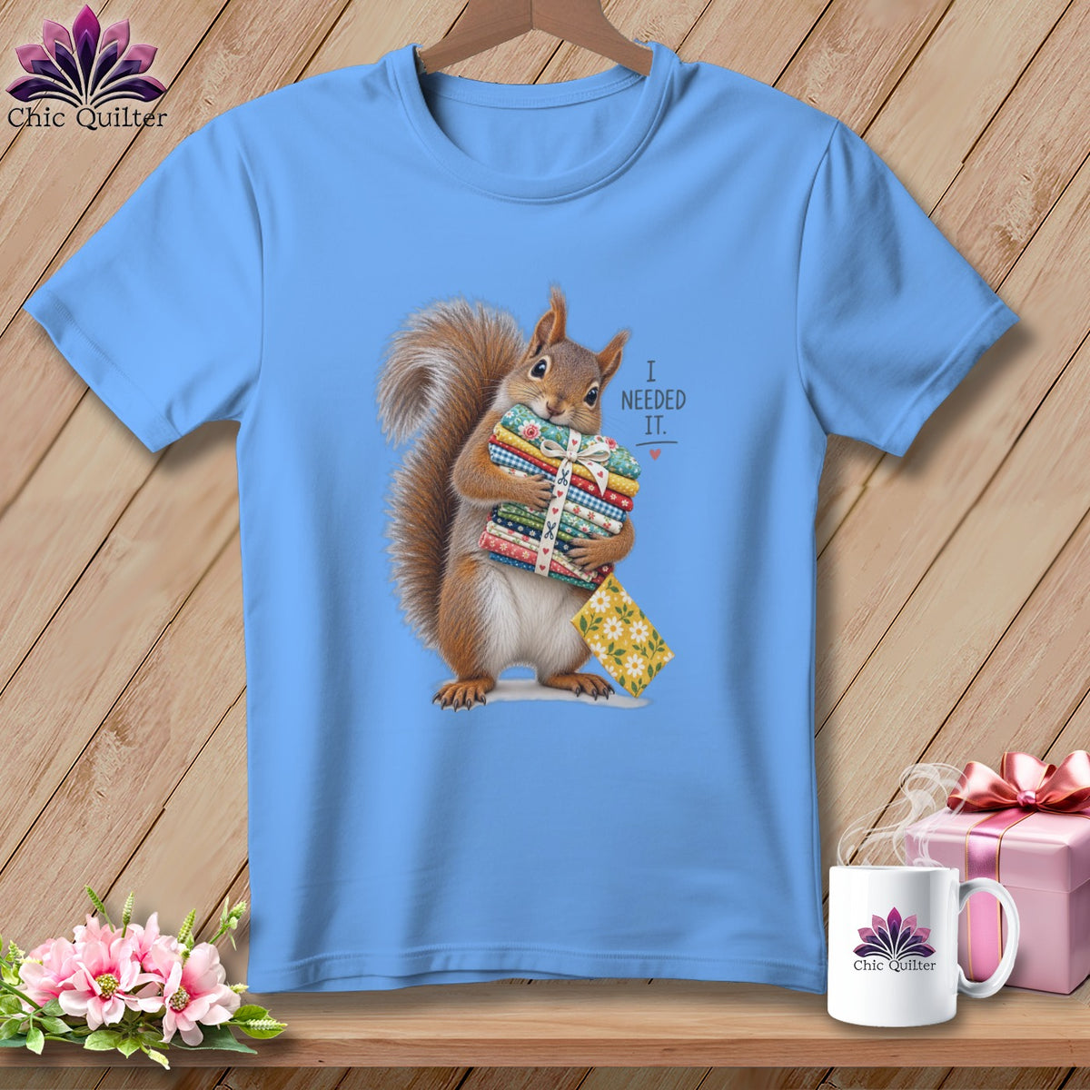 Squirrel holding a stack of fabric bundles with text "I NEEDED IT."