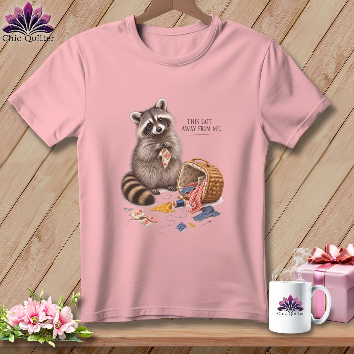Pink t-shirt with raccoon and sewing supplies graphic, text reads "THIS GOT AWAY FROM ME."