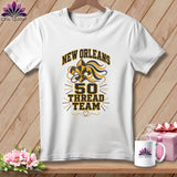 White crewneck t-shirt with black and gold New Orleans 50 Thread Team graphic on wooden background.