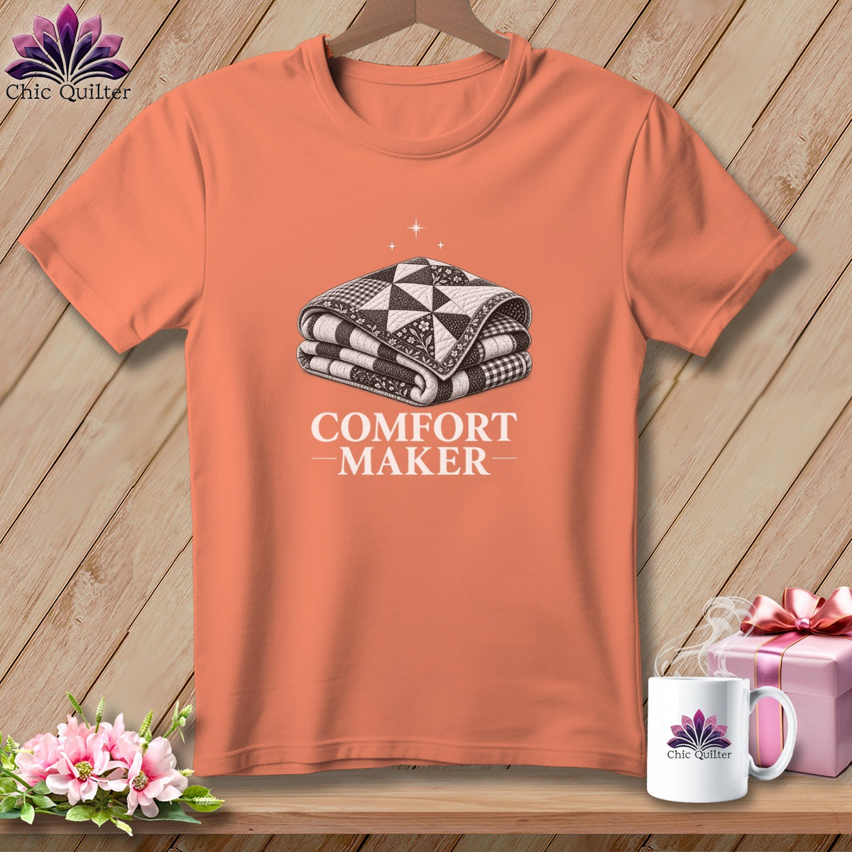 Coral t-shirt with a sketch of folded quilt and "COMFORT MAKER" text.
