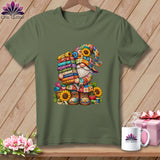 An olive green t-shirt displays a colorful graphic of a gnome holding a stack of folded fabrics.