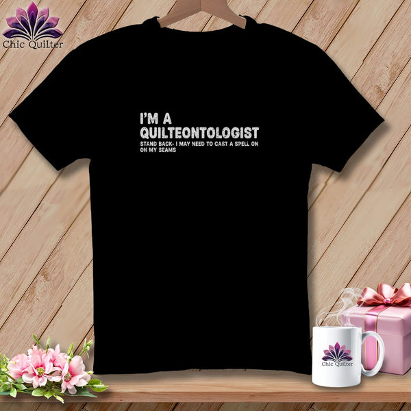 Black t-shirt with "I'm a Quilteontologist" text and a floral logo.
