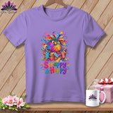 A purple t-shirt featuring a colorful owl in a basket with the text Scrappy & Happy.