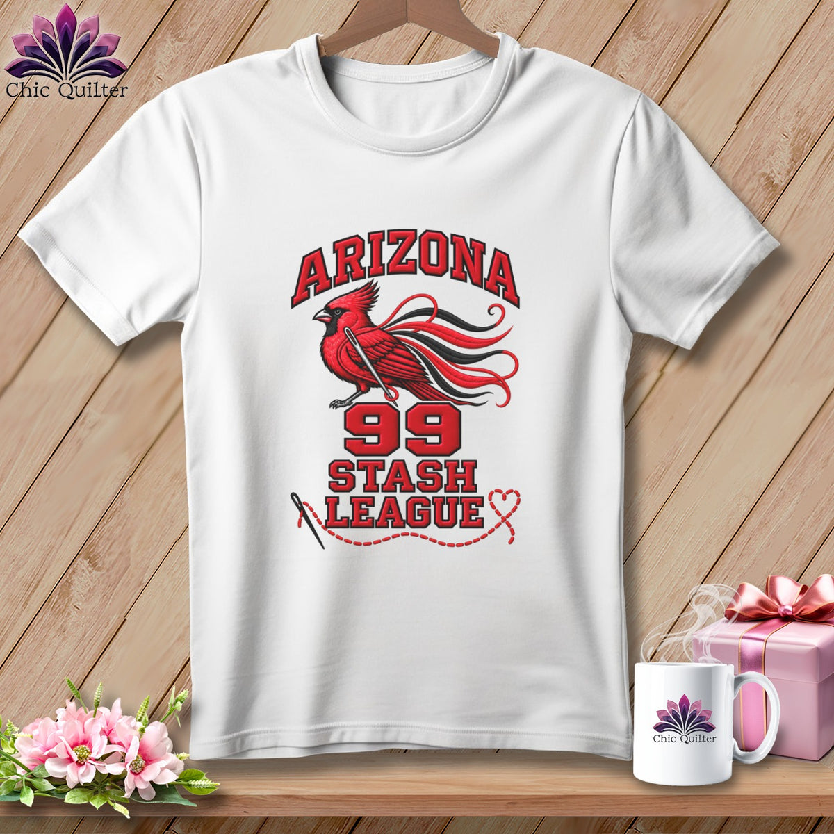A white t-shirt hanging against a wooden background features a graphic with a red cardinal and text reading Arizona 99 Stash League.