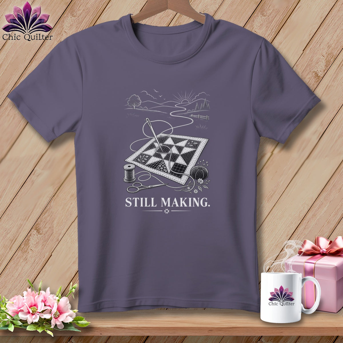 T-shirt with a line drawing of quilting supplies and a landscape with the text "STILL MAKING."