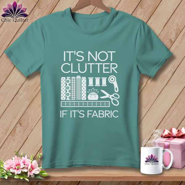 Teal t-shirt with "IT'S NOT CLUTTER IF IT'S FABRIC" text and sewing icons.