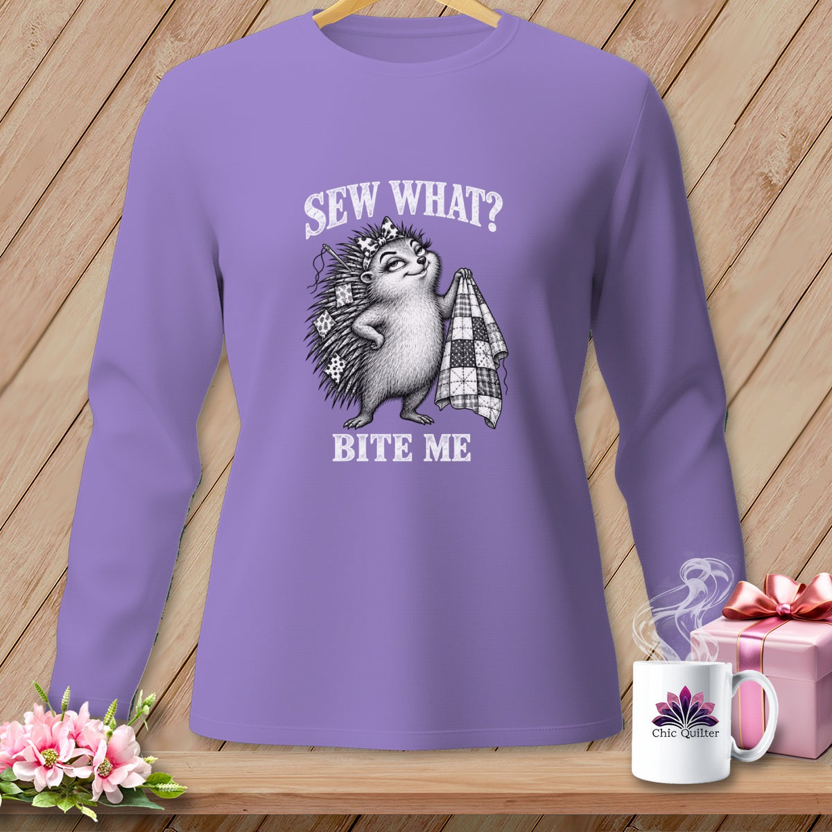 Purple long-sleeve shirt with a graphic of a hedgehog holding a quilt and the text SEW WHAT? BITE ME.