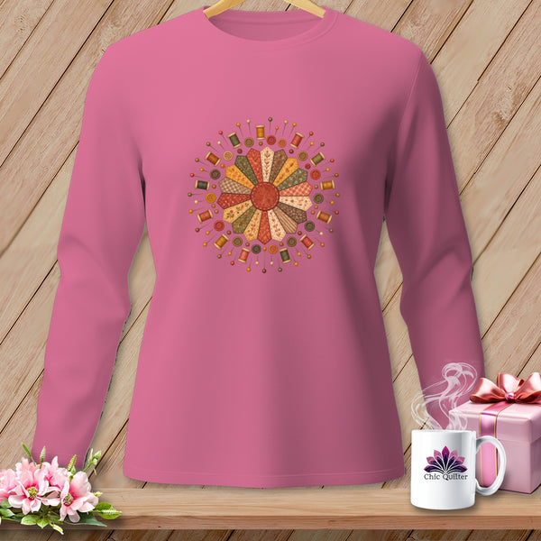 Pink long-sleeve shirt with a colorful floral quilt block and sewing notions design.