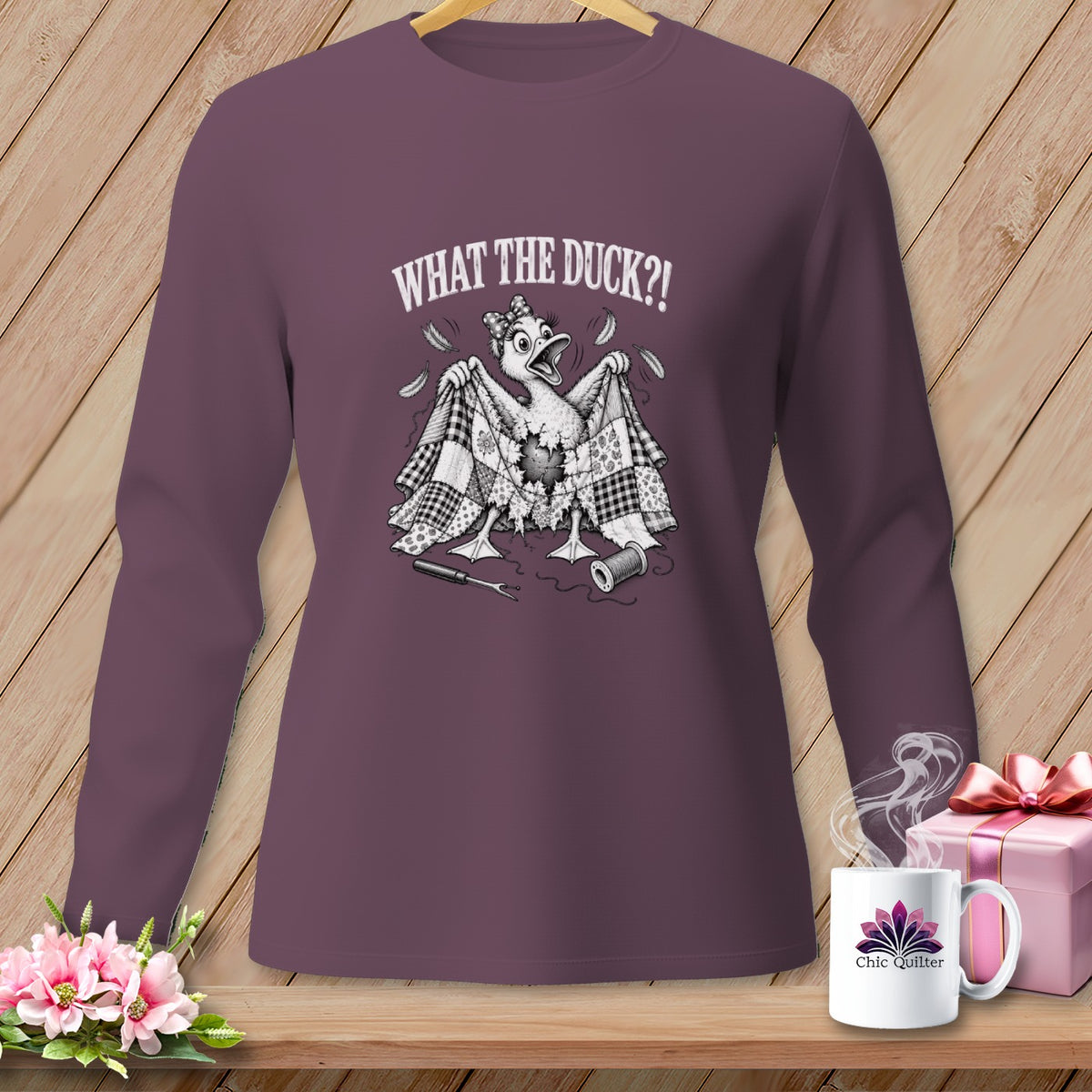 Plum long-sleeve shirt featuring a graphic of a startled duck under a torn quilt with text.