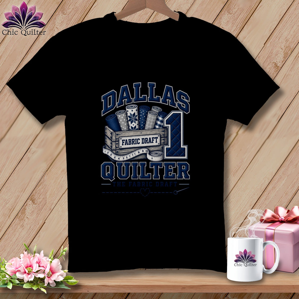 A black t-shirt displays blue and white graphics including a wooden crate with fabric bolts, a large number one, and text reading Dallas Quilter.