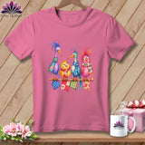 A pink t-shirt displays a graphic of four colorful cartoon birds wearing scarves on a rod.