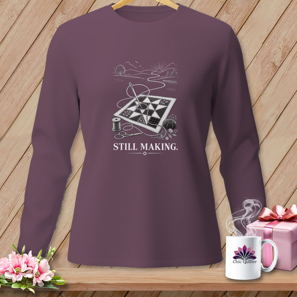 Long sleeve shirt with quilting design, needle, thread, and scissors. Text reads "STILL MAKING."
