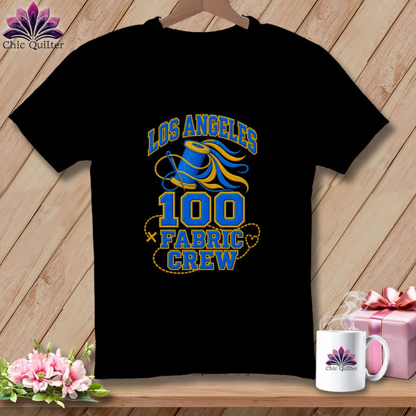 A black t-shirt featuring a blue and yellow graphic with text reading Los Angeles 100 Fabric Crew.