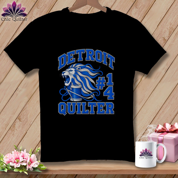 Black t-shirt featuring a blue and white graphic with a lion, spool of thread, and text reading Detroit Quilter.