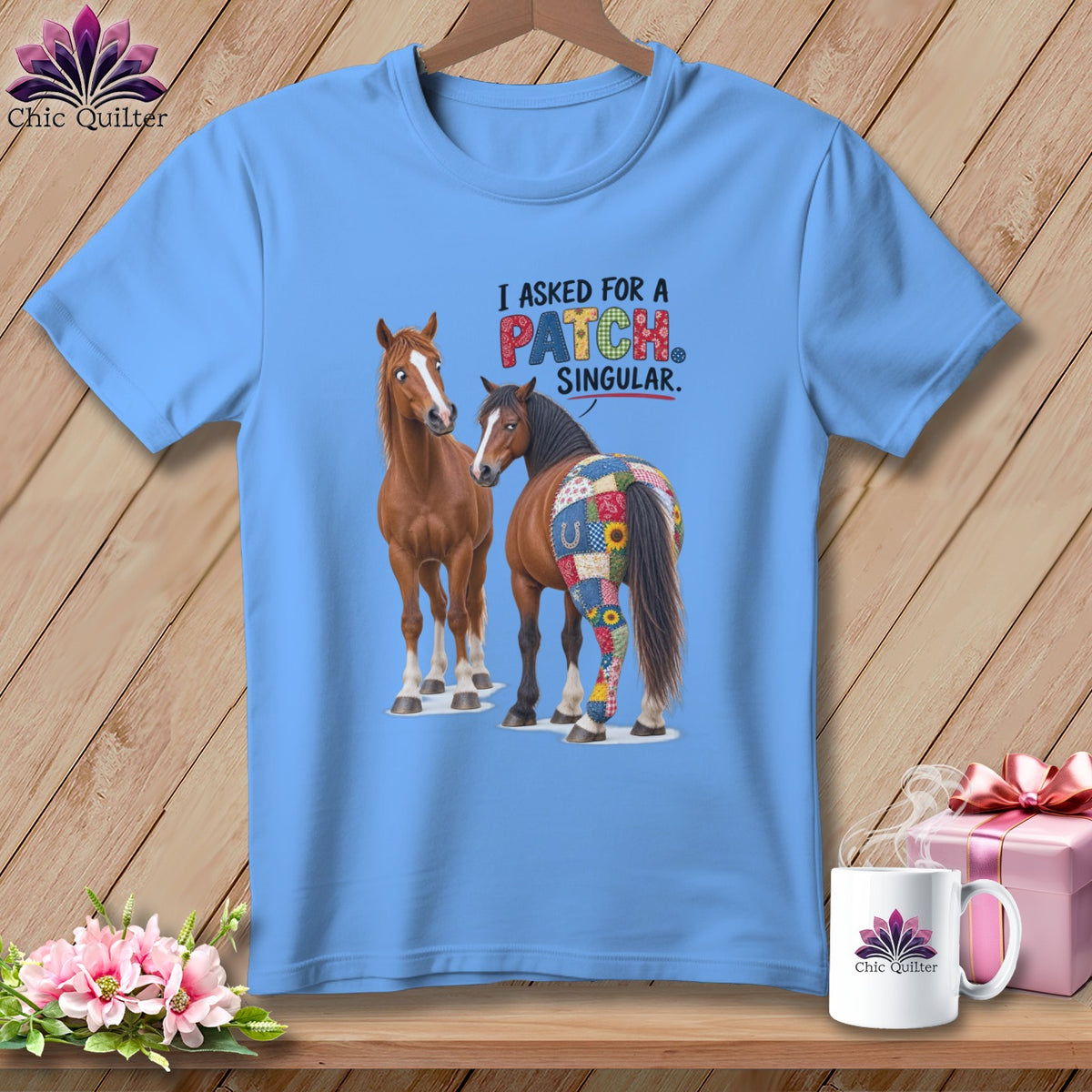 Light blue t-shirt with two horses, one with a patchwork quilt pattern on its hindquarters.