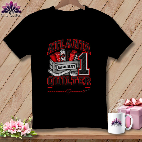 Black t-shirt featuring a red, white, and black graphic with the text Atlanta Quilter and a crate of fabric rolls.