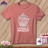 Pink t-shirt with a graphic of a basket overflowing with fabric rolls and stacks, text reads 