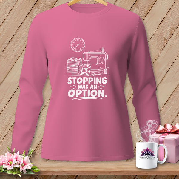 Pink long-sleeve shirt with white graphic of a sewing machine, fabric stacks, and the text "Stopping Was An Option".