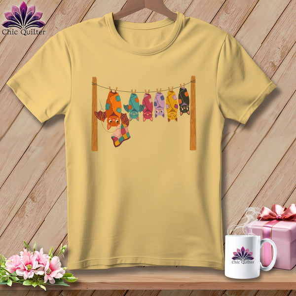 Yellow t-shirt with a row of colorful, hanging cartoon bats and "Chic Quilter" logo on mug.