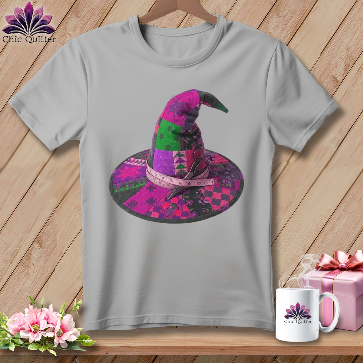 Gray t-shirt with patchwork witch hat graphic, measuring tape, and scissors.