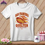 White crewneck t-shirt featuring a San Francisco Quilter graphic with buttons, ribbons, and text on a wooden background.