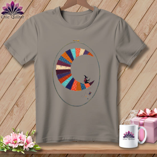 Gray t-shirt featuring a patchwork crescent moon with a witch riding it.