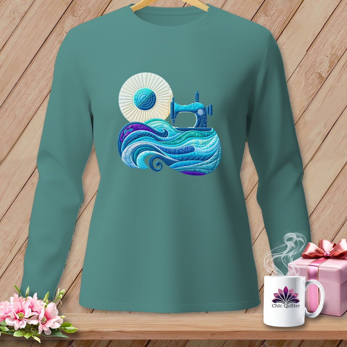 Long-sleeved teal t-shirt with a sewing machine and yarn graphic.