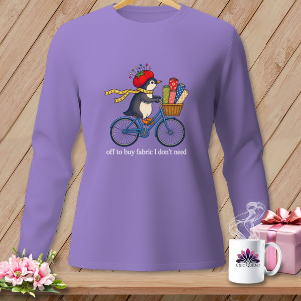 Penguin on a bicycle with fabric rolls, wearing a tomato pincushion hat, text "off to buy fabric I don't need".
