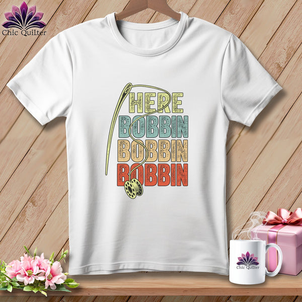 White t-shirt with text "HERE BOBBIN BOBBIN BOBBIN" and a sewing needle.