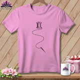 Pink t-shirt with a black spool of thread and needle graphic.