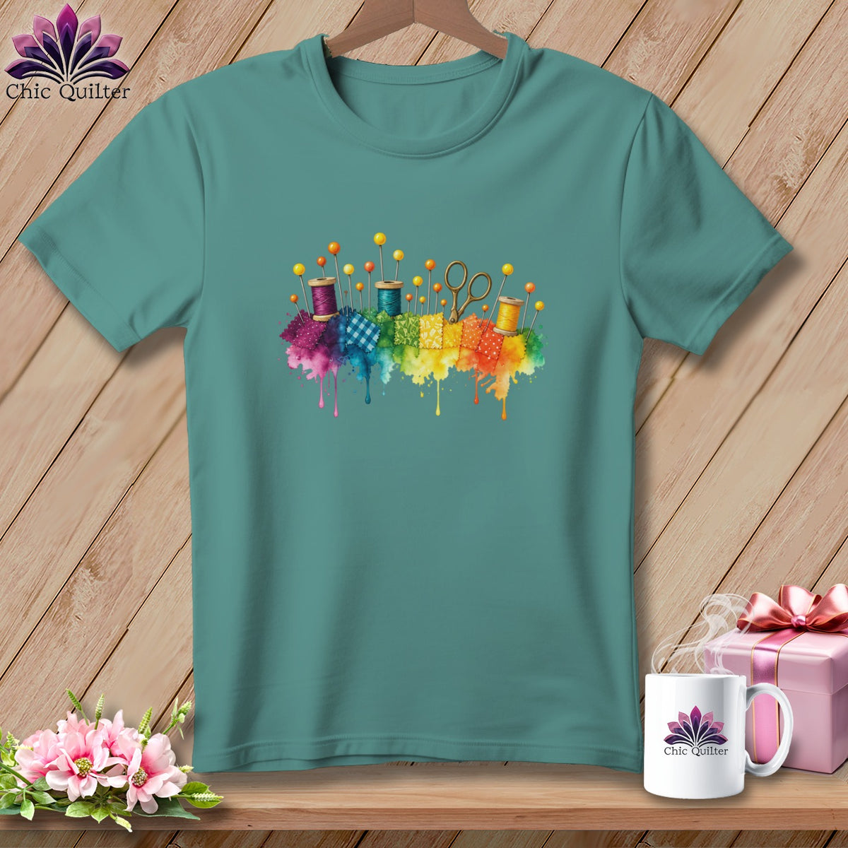 Teal t-shirt with colorful sewing notions and fabric squares graphic.