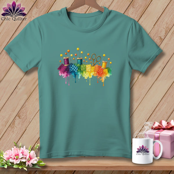 Teal t-shirt with colorful sewing notions and fabric squares graphic.