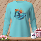 A turquoise long-sleeve shirt displays a circular graphic featuring a vintage sewing machine, stylized waves, and a sun.