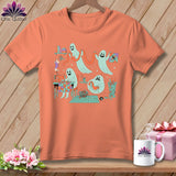 Peach t-shirt with a screen print of cute ghosts sewing and crafting.