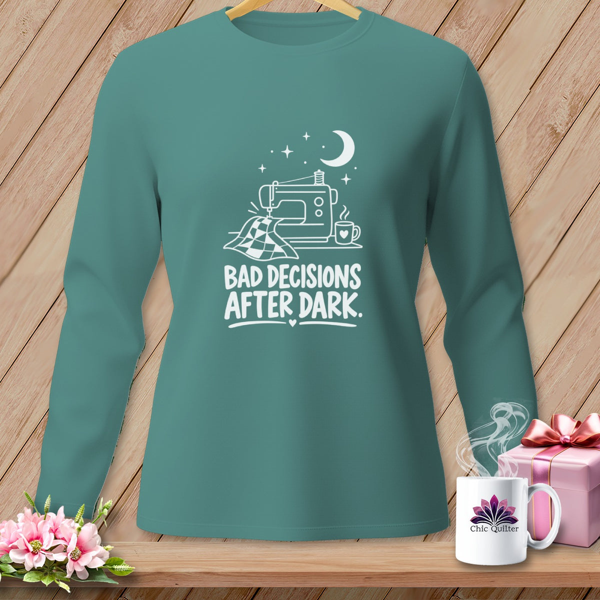 Teal long-sleeve shirt with sewing machine, quilt, and text "BAD DECISIONS AFTER DARK."