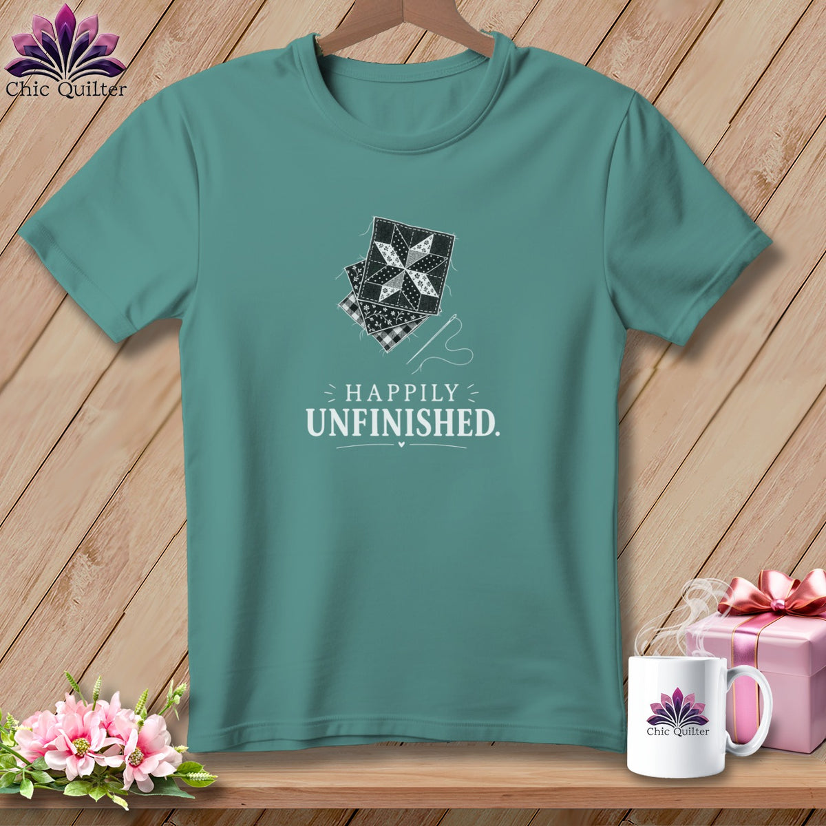 Teal t-shirt with stacked quilt squares and "Happily Unfinished" text.