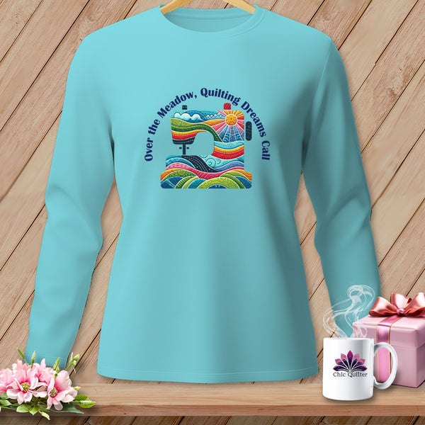 Aqua long sleeve shirt with a colorful sewing machine graphic and text "Over the Meadow, Quilting Dreams Call".