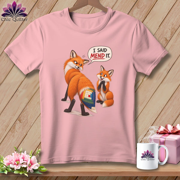 Pink t-shirt with two foxes, one with a quilted tail, and text "I SAID MEND IT."